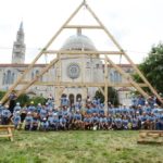 Group shot of the team that completed the first successful 'raising' of a replica truss at Catholic University of America (CUA) in August 2021; the team consisted of over 50 architects, carpenters, and students.