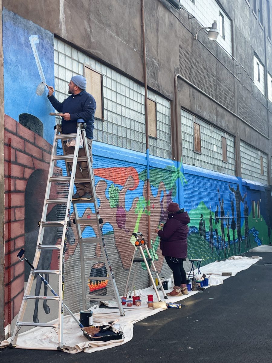 Justin Como as Lead Artist at the Stone Soup American Bistro and Beer Garden Mural Event. Justin Como as Lead Artist at the Stone Soup American Bistro and Beer Garden Mural Event.